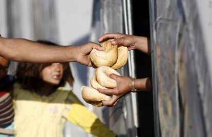 Un voluntario entrega pan a refugiados sirios en un campo de refugiados en el distrito de Suruc en Sanliurfa (Turquía).
