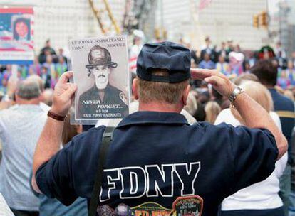 Un bombero sujeta el jueves,  séptimo aniversario del 11-S, el retrato de un colega fallecido en  las Torres Gemelas.