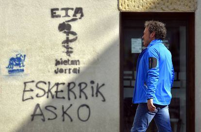 Un hombre camina junto a un grafiti de ETA, este viernes en Oiartzun (País Vasco).