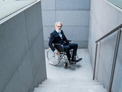 Una persona con discapacidad frente a una escalera.