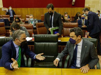 El presidente andaluz, Juan Manuel Moreno (derecha), y el consejero de la Presidencia, Elías Bendodo, en sus escaños al comienzo del pleno del Parlamento de Andalucía que se ha celebrado este miércoles en Sevilla.