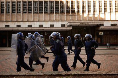 Agentes de la policía antidisturbios zimbabuenses patrullan en las calles de Harare, el 1 de agosto de 2018-
