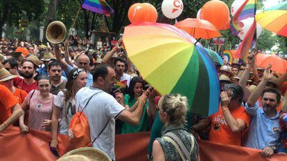 Un miembro del equipo de Ciudadanos, con un paraguas delante de Inés Arrimadas, durante el Orgullo.