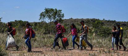 Venezolanos caminan en Pacaraima, Brasil, tras cruzar la frontera. 