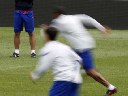 Simeone observa a sus jugadores durante el entrenamiento de esta mañana