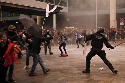 Policies antidisturbis carreguen contra els manifestants a l'exterior de l'aeroport del Prat.
