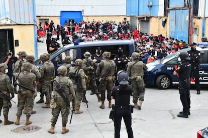 Agentes de la Policía Nacional y miembros del Ejército custodian a los inmigrantes que están en las naves del Tarajal, el martes.