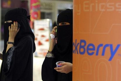 Dos mujeres hablan por sus Blackberrys en un centro comercial de Riad (Arabia Saudí).