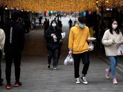 Varias personas en una calle comercial en Wuhan (China).