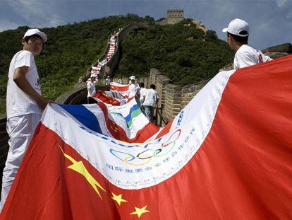 Voluntarios chinos sostienen una bandera formada con distintos escudos nacionales.