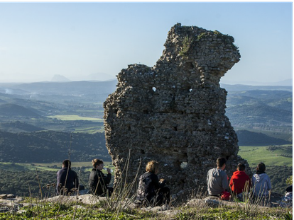 Un grupo de personas observa los restos de la muralla de Lacipo