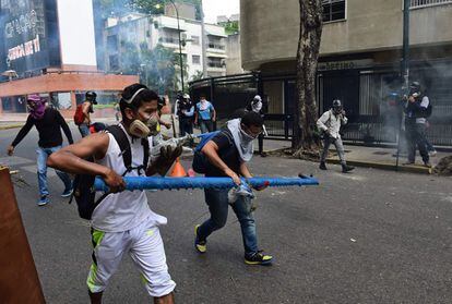 Un grupo de manifestantes contrarios al gobierno de Nicolás Maduro se enfrenta a la policía en las calles de Caracas durante la protesta contra el presidente venezolano.