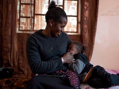 Mbayam Diop, de 30 años y esposa de emigrante, acaricia a su hija Mamita en el salón de su vivienda en Gandiol, en el distrito senegalés de Saint Louis.