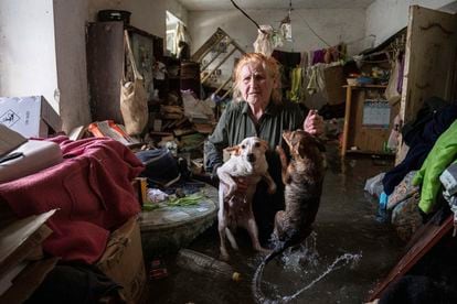 Una mujer sujeta a sus mascotas, en su casa inundada, en Jersón.