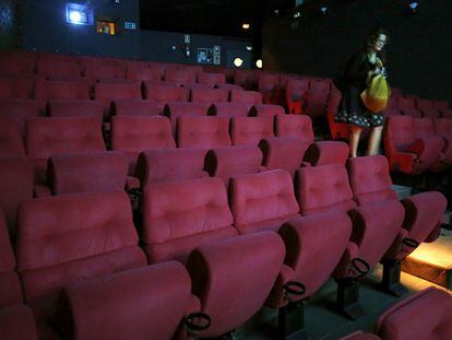 Una espectadora abandona una vacía sala de un cine madrileño.