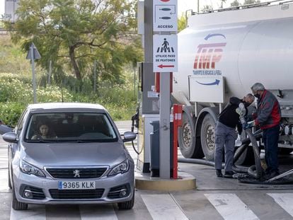 Un operario hace mediciones y llena los depósitos de carburante desde un camión cisterna en una gasolinera de Sevilla.