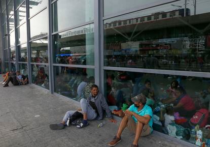 Dos migrantes platican afuera de la estación de autobuses. Elementos del INM han acudido a la terminal para advertirle a los cientos de personas que esperan ahí, que no realicen viajes a las ciudades fronterizas, argumentando que la visa de la que gozan únicamente les permite permanecer en México.