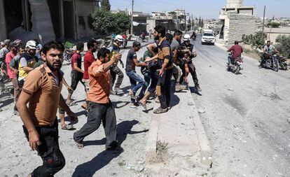 Civiles y miembros de la Defensa Civil Siria trasladan un cuerpo en la provincia de Idlib.
