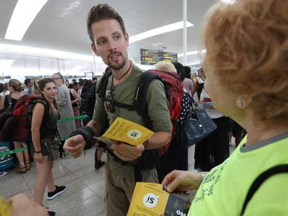 Voluntarios de la ANC reparten folletos pidiendo el 'sí' a la independencia en las colas de El Prat