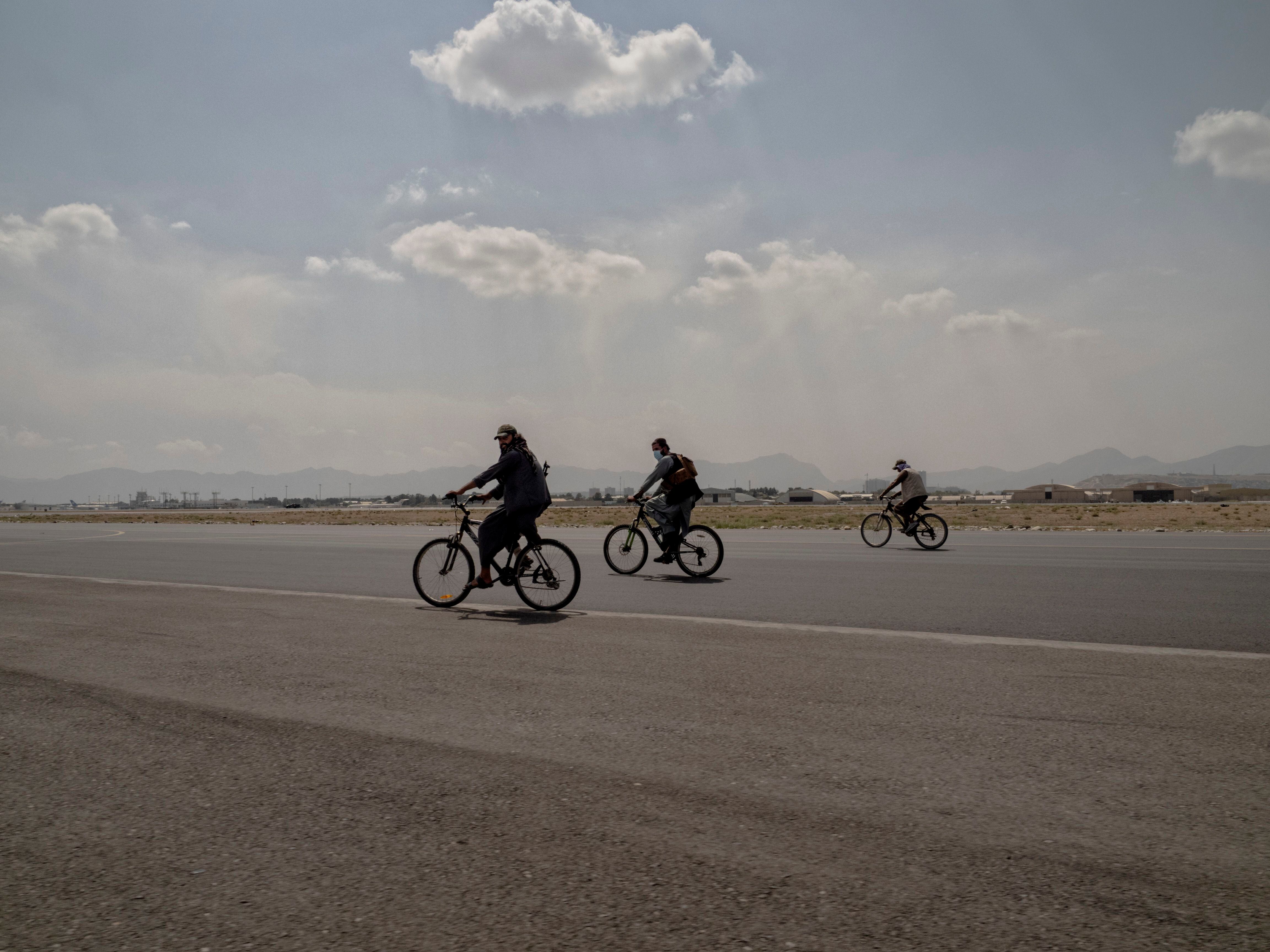 Varios talibanes recorren en bici la pista del Aeropuerto Internacional Hamid Karzai, la mañana siguiente a que Estados Unidos dejara oficialmente el país.