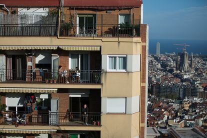 Los vecinos de un edificio de Barcelona se asoman a sus terrazas durante el confinamiento.