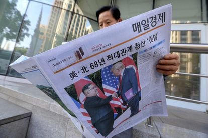 Un hombre lee un periódico que luce en su portada la imagen de ambos mandatarios, en Seúl (Corea del Sur).