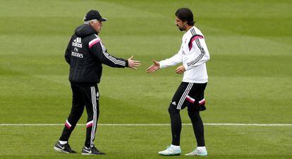 Carlo Ancelotti tiende la mano a Sami Khedira durante el entrenamiento de este miércoles en Valdebebas.