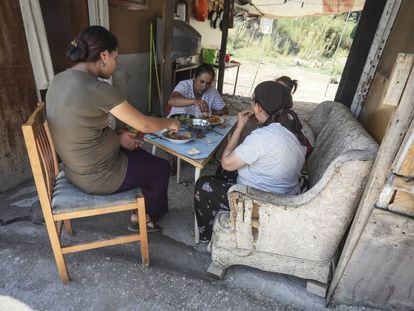 Un grupo de mujeres come bajo el tejado de una chabola del Gallinero.