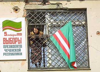 Una empleada, en un centro electoral de Grozni con la bandera chechena.