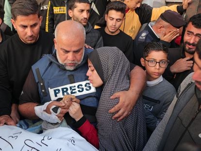 El periodista de Al Jazeera Wael al Dahdouh coge la mano de su hijo Hamza, también informador y fallecido en un ataque israelí, mientras abraza a una de sus hijas el 7 de enero.