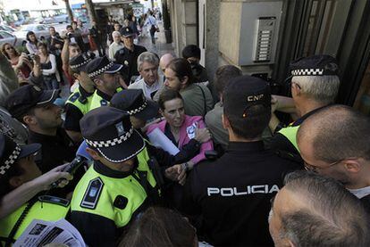 La policía forcejea con activistas ante la sede de Paz Ahora, en la calle Princesa.