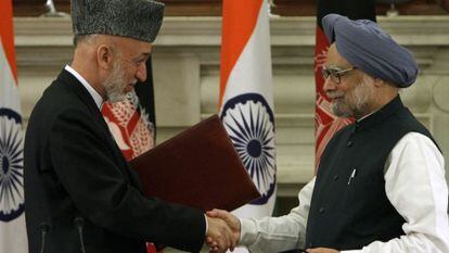 Hamid Karzai y Manmohan Singh se saludan tras firmar el acuerdo bilateral.