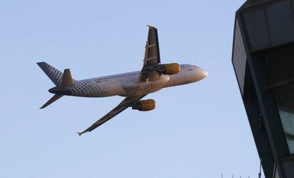 Un avión A320-200 de Vueling sobrevuela la torre de control del aeropuerto de Barcelona-El Prat.