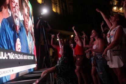 Votantes festejan al ver a Lula dar su discruso en una pantalla en Río.