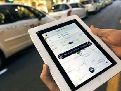 Un usuario de Uber consulta la aplicación en Valencia ante una parada de taxis.