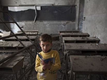 Ali, de 9 años, posa en su escuela, destruida por un bombardeo, en Alepo.