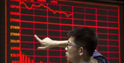 Un inversor contempla un panel con la cotización de la Bolsa de Pekín