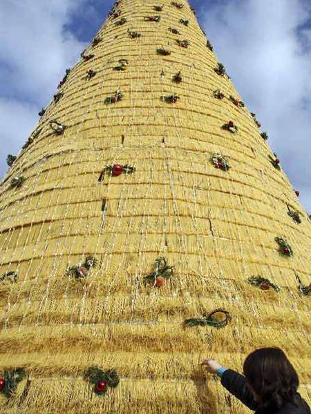 Una mujer toca el árbol de Navidad hecho con espaguetis en Tirana