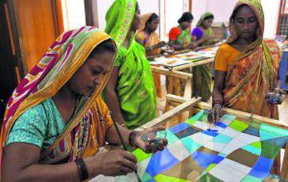 Mujeres trabajan pintando pañuelos en India.