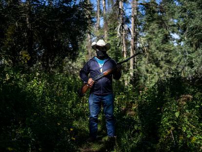 Un miembro de la guardia forestal comunitaria de Crescencio Morales, en Michoacán, posa con su escopeta en los bosques de la Reserva de la Biosfera de la Mariposa Monarca, el 8 de diciembre de 2021.