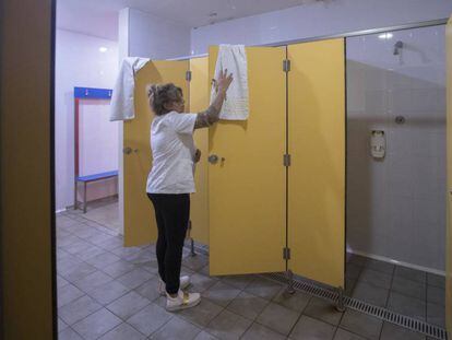 Una treballadora neteja les dutxes del centre de dia de Meridiana