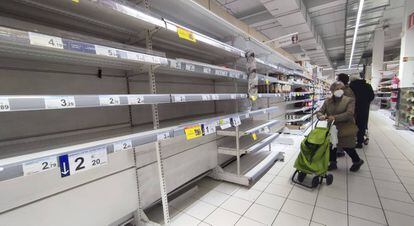Una mujer observa unas estanterías vacías de legumbres en un supermercado de Madrid. 