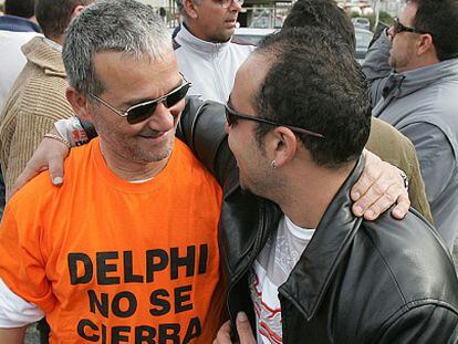 Dos antiguos trabajadores se abrazan en el aniversario del cierre de Delphi en 2008.