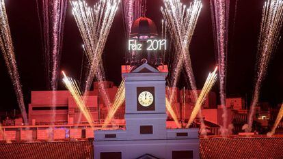 El reloj de la Puerta del Sol da las campanadas de fin de año, frente a la mirada de miles de personas.