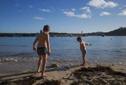 Dos niños juegan en la playa el día 2 en St Ives, Cornwall (Inglaterra).