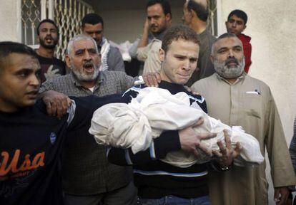 Jihad al-Masharawi porta el cuerpo de su hijo Omar camino del cementerio.