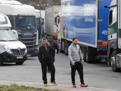 Dos camioneros y varios camiones estacionados en la explanada de acceso a Pedrafita do Cebreiro.