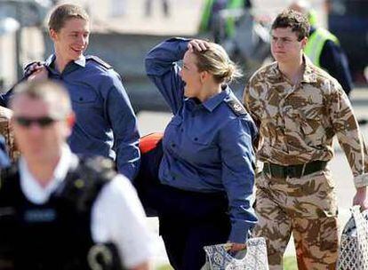 Los marinos Faye Turney (centro) y Andrew Henderson (izquierda) ríen al llegar al aeropuerto de Heathrow.