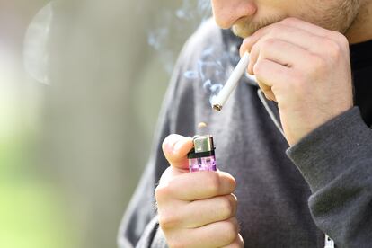 Un hombre enciende un cigarrillo en la calle con un mechero, en una imagen de archivo.