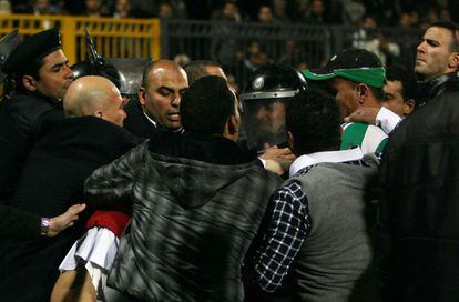 La policía egipcia intenta contener a algunos de los hinchas que se lanzaron al campo de fútbol de Port Said al finalizar el partido.